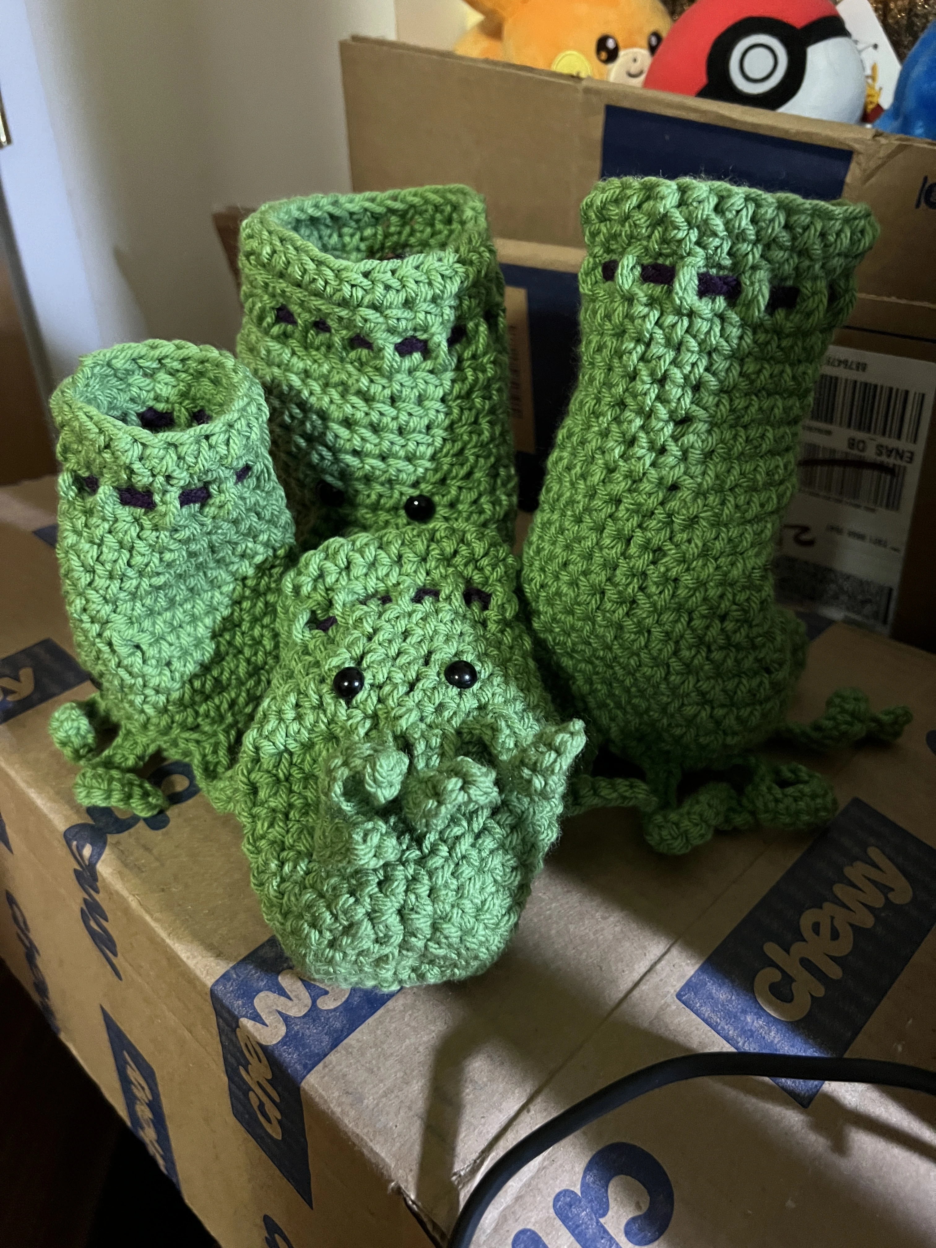 4 green crochet dice bags with black eyes and tentacles
